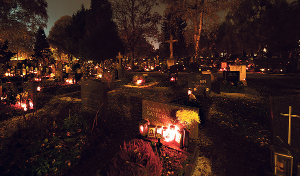 Zu Allerheiligen und Allerseelen besuchen viele Menschen das Grab von Verstorbenen am Friedhof. Auf den Gräbern brennen viele Kerzen. 