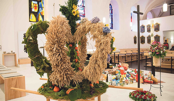 Vor der Erntekrone findet sich ein Berg an Lebensmitteln.  