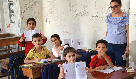 Die jungen Schülerinnen zeigen stolz ihre Schreibhefte. Das Schulprojekt in Damaskus wird von ICO unterstützt. 
