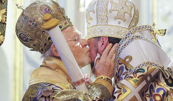 Bartholomaios I., Ökumenischer Patriarch von Konstantinopel (links), küsst den neuen ukrainischen Metropoliten Epiphanius und überreicht ihm die Urkunde, welche die Eigenständigkeit der ukrainischen Kirche besiegelt.  