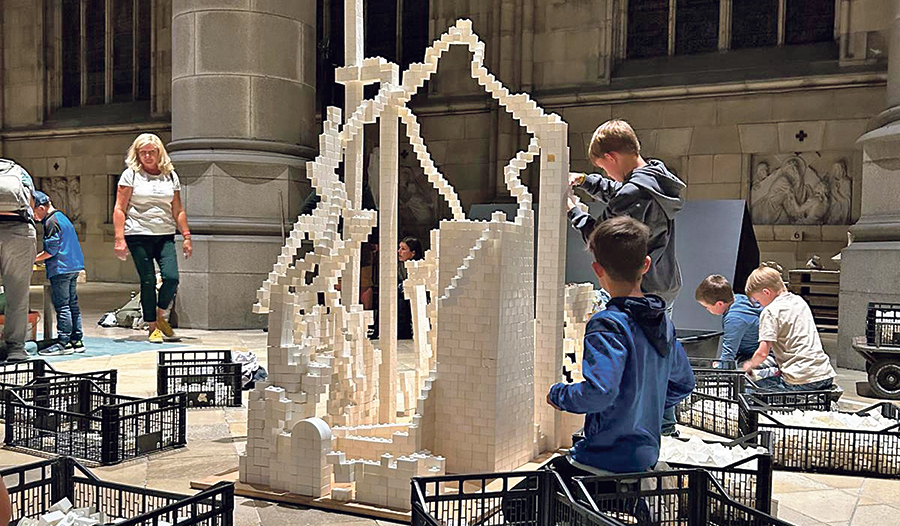 Kinder bauten eine Kirche aus Klemmbausteinen.  