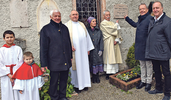 Vertreter:innen von Pfarre und Gemeinde bei der Gedenktafel für Pfarrer Weidinger.   
