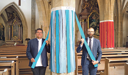 Pfarrassistent Roland Altreiter (links) mit dem Obmann des Pfarrgemeinderates  Simon Voggeneder bei einer beschrifteten Säule in der Pfarrkirche Freistadt.  