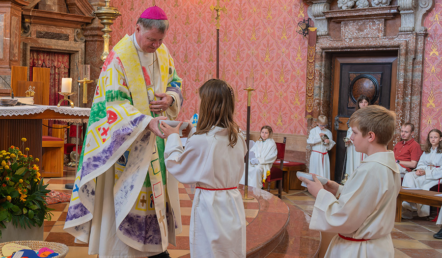 Bischof Manfred Scheuer und zwei Ministrant:innen