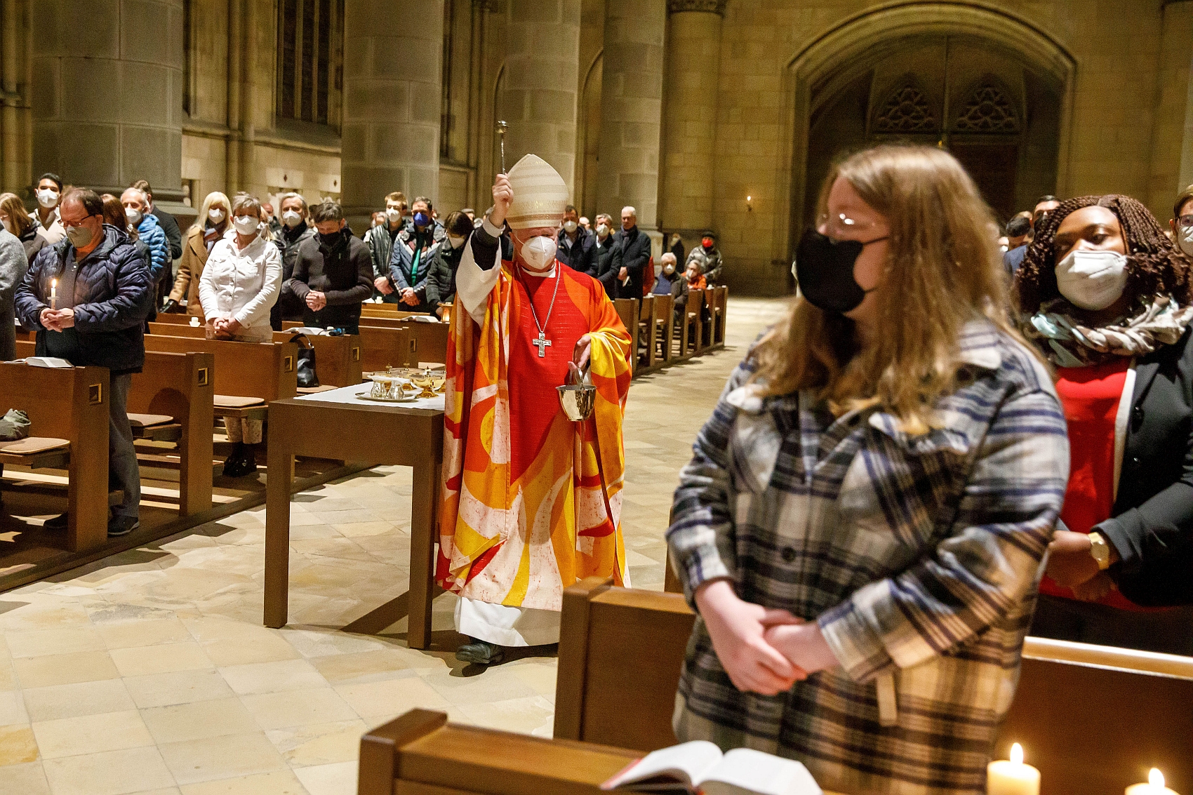 Bischof Manfred Scheuer besprengt die Gläubigen nach der Tauferneuerung mit Weihwasser
