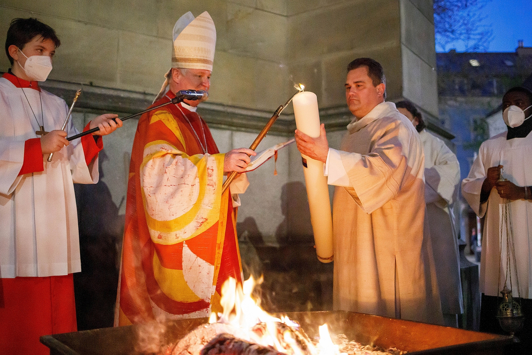 Bischof Scheuer entzündet am Osterfeuer die Osterkerze.