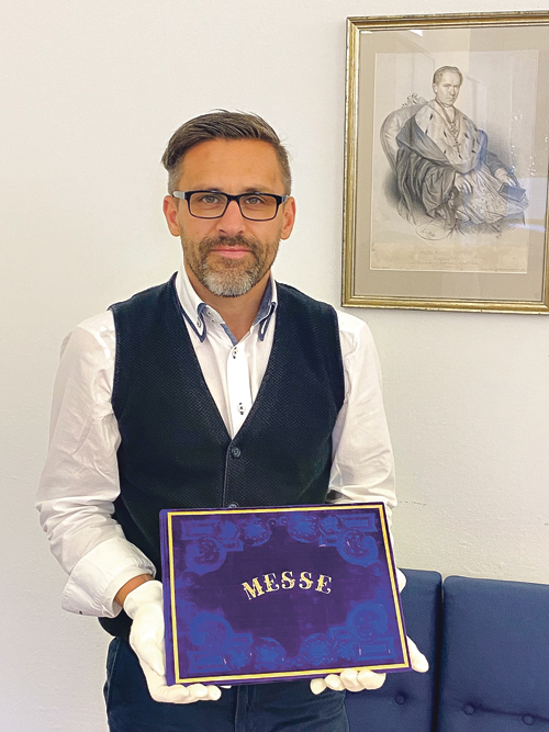 Klaus Birngruber, der Leiter des Diözesanarchivs mit der „Prunkausgabe“ von Bruckners e-Moll-Messe. Im Bild hinten: Bischof Franz Joseph Rudigier.   